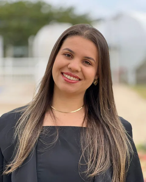Fernanda Alves, mentorada, sorrindo ao ar livre
